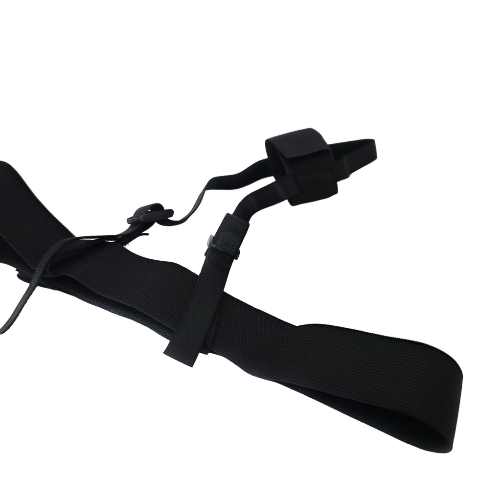 A black adjustable elastic hands free strap with plastic buckle closures, laid out on a white satin-like fabric surface.