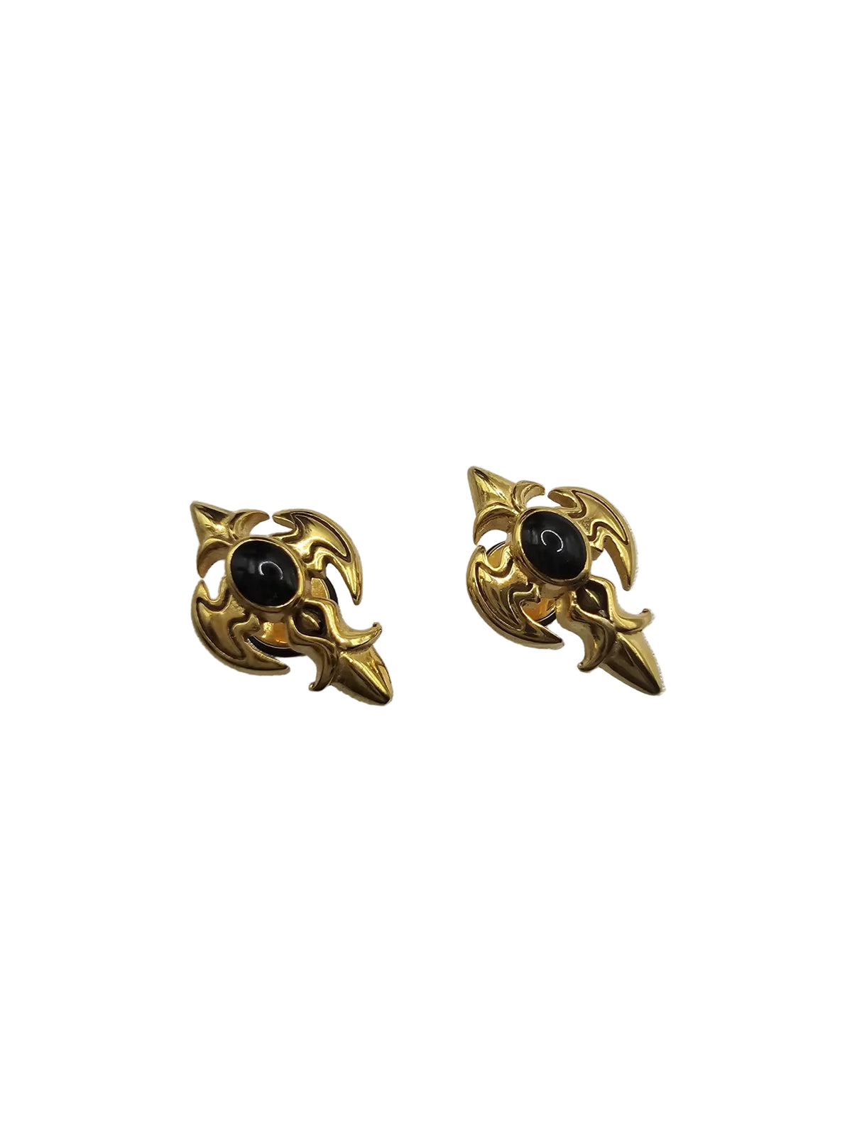 A pair of vintage-style gold-toned earrings with a central black oval stone, displayed on a textured light gray fabric background.