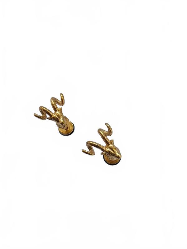 A pair of gold-toned stud earrings shaped like stylized deer heads with curved antlers, shown on a plain white background.